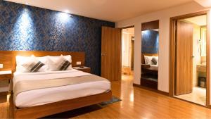 新德里The Orion Plaza - Nehru Place的一间卧室配有一张蓝色墙壁的床