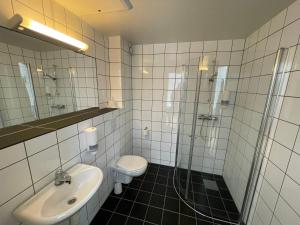 Rauland劳兰德学院青年旅馆的浴室配有卫生间、盥洗盆和淋浴。