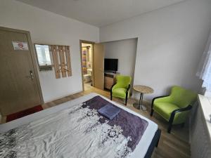 考纳斯Lux kambarys centre su karališka lova #3的一间卧室配有一张床和两张绿色椅子
