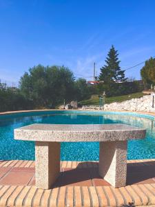 希维利Villa Cultura Elani Halkidiki的游泳池前的石凳