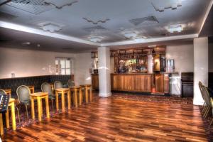 克里基厄斯乔治四世酒店的一间酒吧,房间内设有木桌和椅子