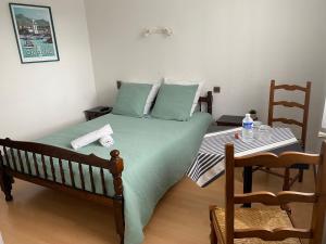 PoueyferréL' Auberge Campagnarde, Lourdes的一间卧室配有一张绿色的床和一张桌子