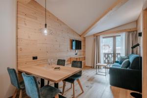 圣维吉利奥Garni Residence Alnö - Adults Only的客厅配有桌子和沙发