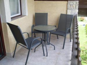 加尔多尼SZIESZTA APARTMAN的庭院里设有三把椅子和一张桌子