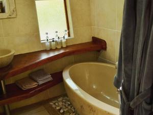 察嫩Waterbessiebos cottage的带浴缸、水槽和镜子的浴室