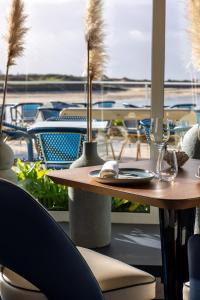 巴讷维尔-卡特里特海洋酒店的阳台上配有带酒杯和椅子的桌子