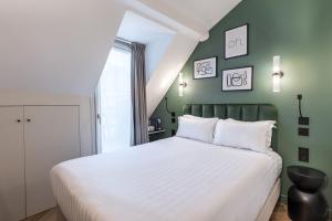 巴黎Hotel Elysée Secret的卧室配有白色的床和绿色的墙壁