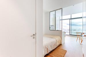 格勒诺布尔Les Appartements de Grenoble的一间卧室配有一张床和一张桌子及椅子