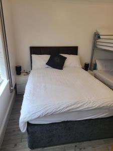 IfieldQUICK STOP-GATWICK STAY, Family Room-GR1的卧室配有一张带白色床单和枕头的大床。