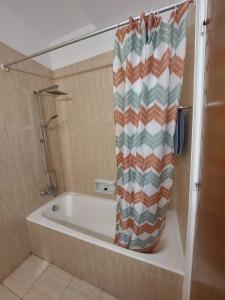 拉纳卡Sunny 2 Bedroom Larnaca Center的浴室设有带浴帘的浴缸