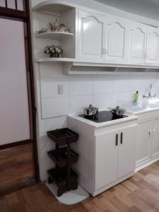 洛哈Acogedor Departamento Central的厨房配有白色橱柜和水槽