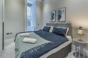 伦敦Green Street Residences by Q Apartments的一间卧室配有一张大床,提供蓝色的床单和枕头