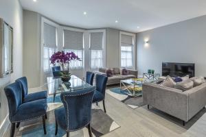 伦敦Green Street Residences by Q Apartments的客厅配有桌椅和沙发