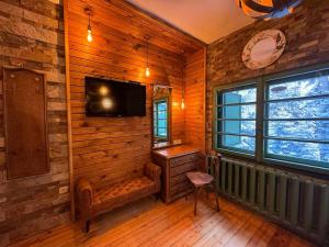 波罗维茨Villa Rila Borovets Mountain & Luxury with Hot Jacuzzi & Sauna的客房设有木墙、电视和椅子。
