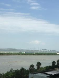 澳门Macanese Elegant Retreat with Fantastic View of HK Zhuhai Macau Bridge的一座水面上的桥梁,在前方有棕榈树