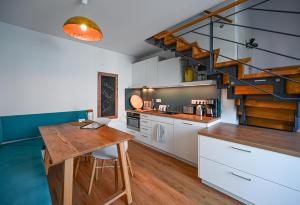腓特烈港EntdeckerFERIEN am Bodensee的厨房设有木桌和螺旋楼梯。