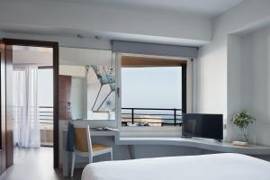 海若克利欧拉托精品酒店的一间卧室配有一张床和一张书桌及电视