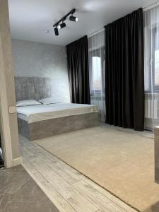 塔拉兹Al-Karakhan的一间卧室配有一张大床和黑色窗帘