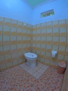 瑟克通Mango Homestay的一间带卫生间和瓷砖墙的浴室