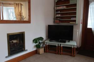 鲍内斯温德米尔Cosy 2-bedroom cottage in the Lake District的客厅配有桌子和壁炉