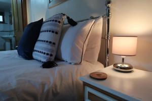 鲍内斯温德米尔Cosy 2-bedroom cottage in the Lake District的一张带枕头的床和一张带台灯的桌子