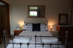 鲍内斯温德米尔Cosy 2-bedroom cottage in the Lake District的一间卧室配有一张带两盏灯和镜子的床