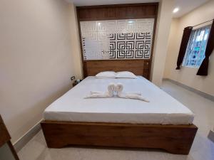 古瓦哈提Hotel Hari Gayatri Regent的一间卧室配有一张带白色床单的床和2个棉被
