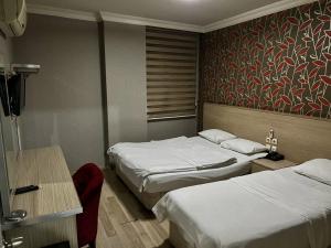 SeyhanOtel Madi的酒店客房设有两张床、一张桌子和一张书桌。