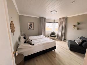GardurGarður Apartments的卧室配有床、椅子和窗户。