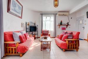 拉戈莱特Flo Villa的客厅配有2张红色沙发和电视