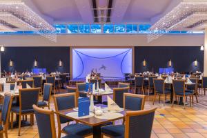宾茨IFA吕根岛度假酒店的一间带桌椅和大屏幕的用餐室