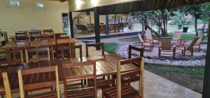 MfuweKUDU SAFARI LODGE (Mfuwe, Zambia)的用餐室配有木桌和椅子
