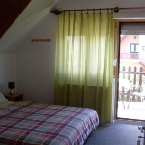 加尔多尼SZIESZTA APARTMAN的一间卧室设有一张床和一个大窗户