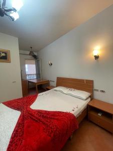 艾因苏赫纳porto sokhna Pyramids Apartment Familis的一间卧室配有一张带红色毯子的大床