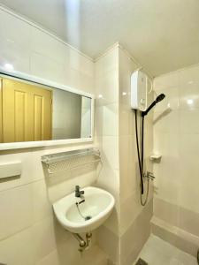 伊洛伊洛Minimalist Condo One Spatial Iloilo 2 Bedroom Unit的白色的浴室设有水槽和镜子