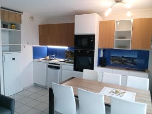 圣拉斐尔appart 6 pers vue mer classé 3*的厨房配有木桌和白色橱柜。