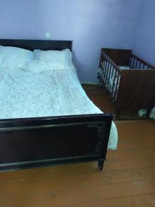 HorsHors guest house by Vanyan的一间卧室配有一张床和一张婴儿床。