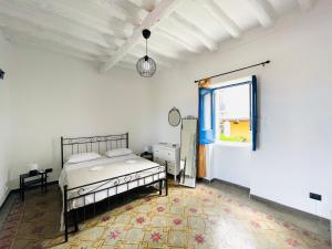 圣马里纳萨利纳Villa Margherita - Appartamenti a due passi dal corso di Santa Marina Salina a 100 mt dalla spiaggia的一间卧室设有一张床和一个窗口