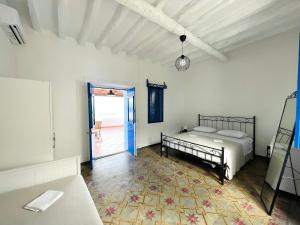 圣马里纳萨利纳Villa Margherita - Appartamenti a due passi dal corso di Santa Marina Salina a 100 mt dalla spiaggia的一间卧室设有一张床,并有通往庭院的门