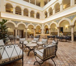 梅里达伊露尼翁梅里达宫酒店的酒店大堂设有桌椅,大楼