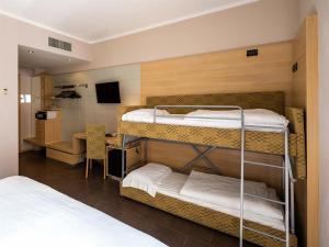 圣费利切德尔贝纳科路易莎别墅度假酒店的客房设有两张双层床和一张书桌。
