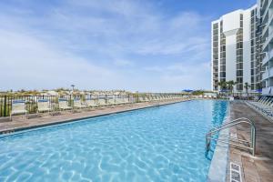 德斯坦Pelican Beach Resort by Panhandle Getaways的一座带椅子的游泳池以及一座建筑