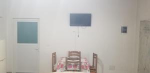 泰斯Villa KRONI的一间设有两把椅子和一台墙上的电视的房间