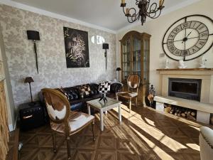 ProañoVilla Liguardi的客厅配有沙发和墙上的时钟
