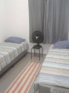 Riacho Fundo(Kit Lucindi)的一间卧室配有两张床和一张黑椅