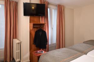 巴黎提姆巴纳斯峰酒店的一间卧室配有一张床,墙上配有电视