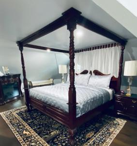 加纳诺克1000 Islands Bed and Breakfast-The Bulloch House的一间卧室配有一张天蓬床和一台电视机