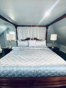 加纳诺克1000 Islands Bed and Breakfast-The Bulloch House的卧室内的一张大床,配有两盏灯