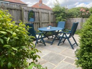 斯泰兹LetAway - Tom's Cabin, Staithes的庭院配有蓝色的桌子和两把椅子