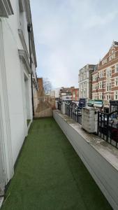 伦敦Kensington Guest Rooms 98的建筑一侧的阳台绿草环绕